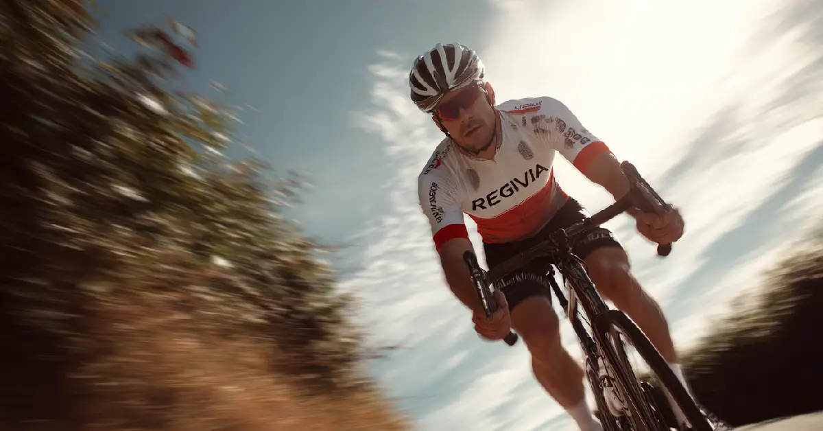 Ciclista amatoriale che rilancia in salita durante un’uscita collinare di fine maggio